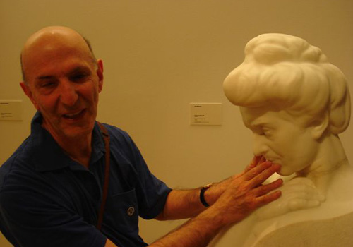 Aldo Grassini esplora tattilmente una scultura in marmo (volto)