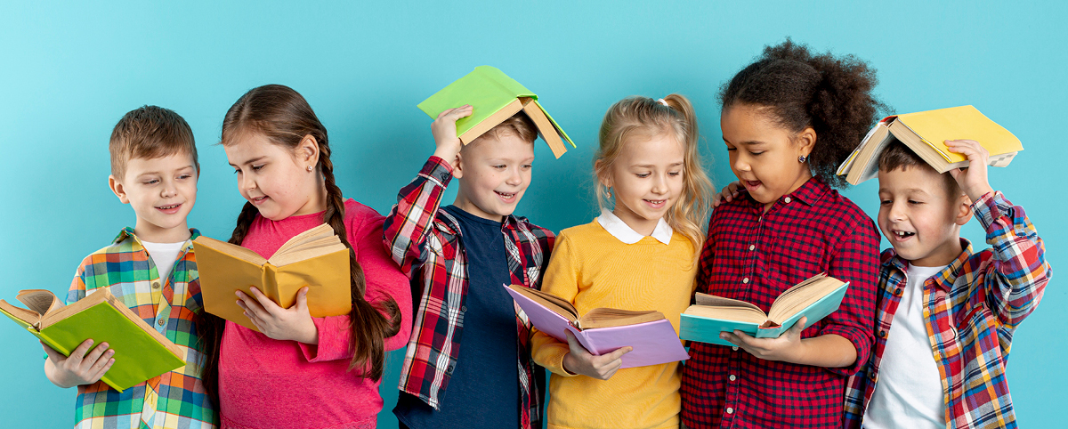 Alcune bambine e alcuni bambini hanno ognuno un libro in mano e si divertono leggendo