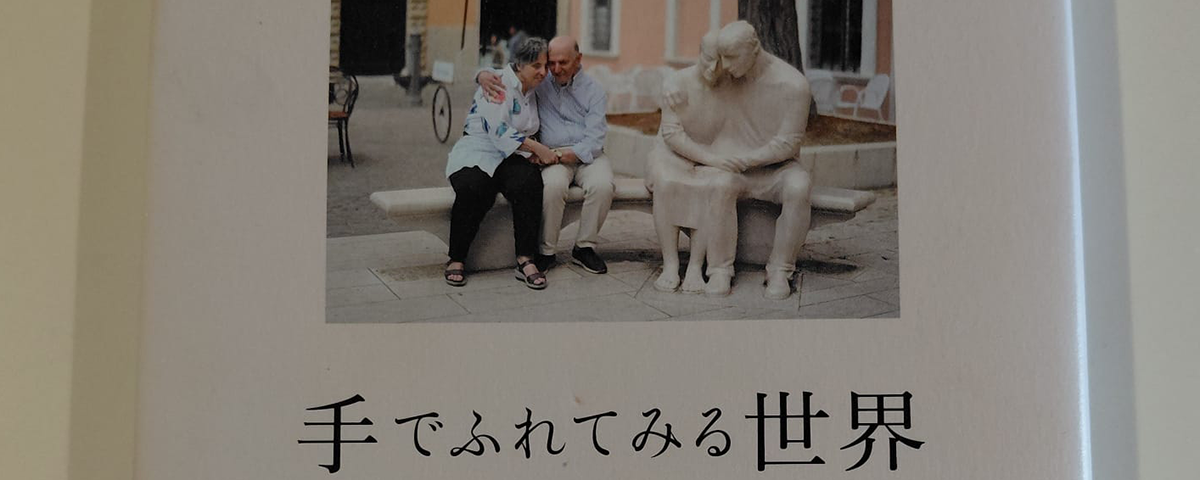 parte della copertina del libro con immagine di Aldo e Daniela che si abbracciano seduti sulla panchina parte dell'opera di Vangi a Pesaro